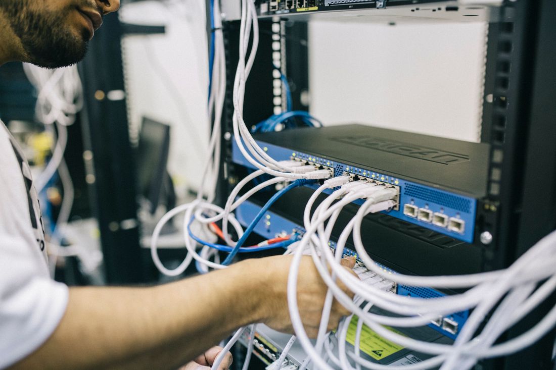 Technician managing server rack and network switches